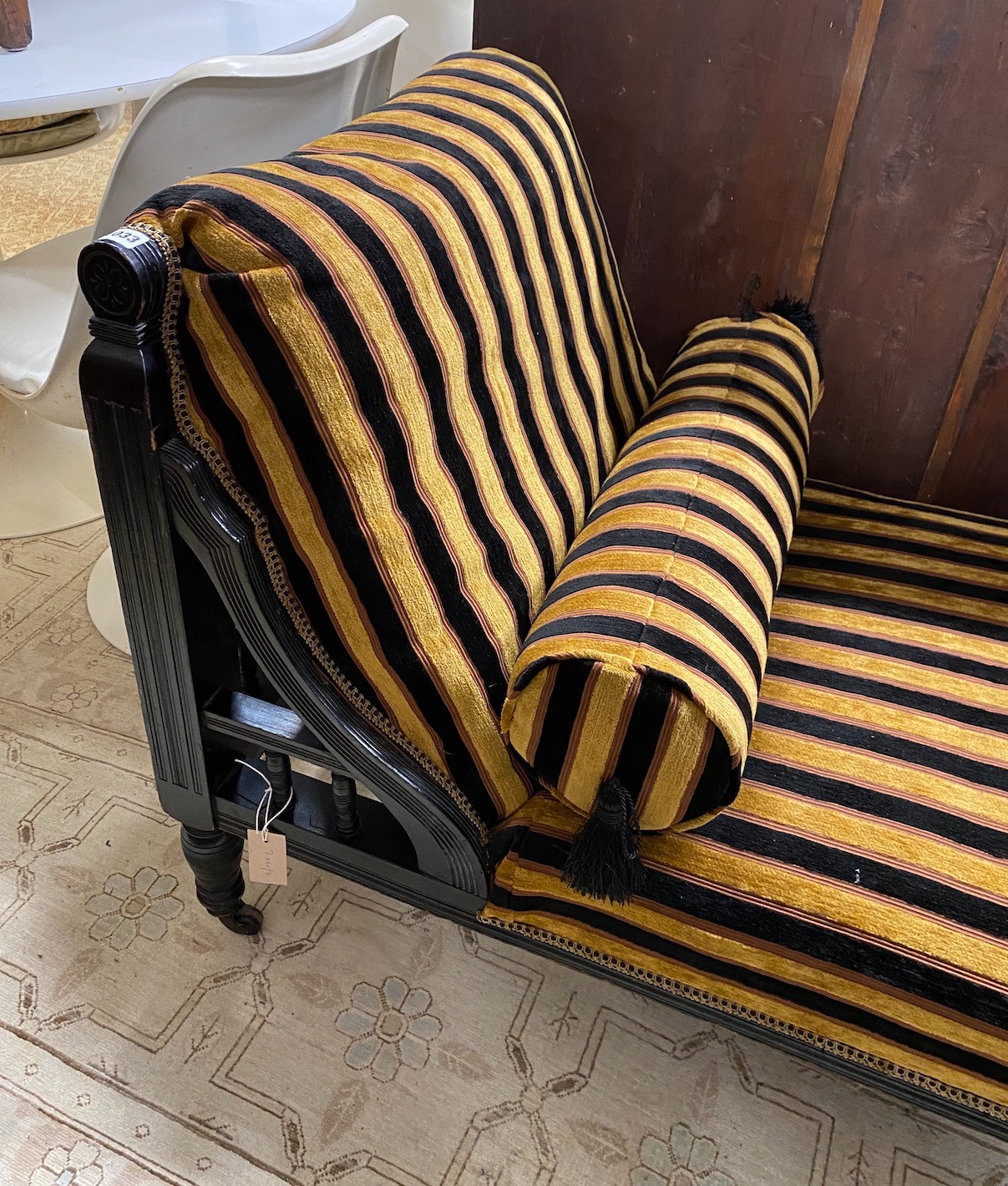 An Aesthetic period ebonised chaise longue, in the manner of E. W. Godwin, length 164cms, depth 61cms, height 75cms.